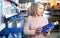 Focused adult woman looking for water in bottles