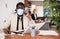 Focused african american businessman in a protective mask talks on a phone in the office