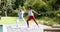 Focused african american couple practicing yoga standing in garden, copy space, slow motion