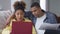 Focused African American man hugging busy woman typing on laptop keyboard. Young husband supporting concentrated