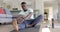 Focused african american man stretching in sunny living room, slow motion