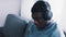 Focused African-American Man wearing headphones sitting on a couch