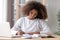 Focused african american school girl studying writing essay doing homework