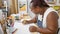 Focused african american woman, captivating artist, drawing with concentration on her notebook at an indoor art studio