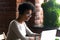 Focused African American woman wearing headphones using laptop