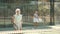 Focused aged woman playing friendly paddleball match on outdoor summer court. Senior people sports concept