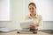 Focused Asian businesswoman examining sales report at her desk, working in the office