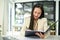 Focused Asian businesswoman reviewing business report on a document folder