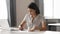 Focused Asian businesswoman signing paper document, writing notes
