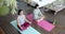 Focused asian female friends practicing yoga meditation on sunny terrace, slow motion