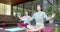 Focused asian female friends practicing yoga meditation on sunny terrace, slow motion