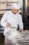 Focused baker sieving flour on the dough