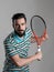 Focused bearded tennis player bend holding racket