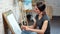 Focused beautiful young designer woman drawing sketch on canvas using gray pencil medium shot