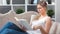 Focused beautiful young girl in trendy glasses reading interesting paper book relaxing on couch