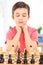 Focused boy playing chess seated at table indoors