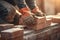 Focused bricklayer installs bricks, close up at construction site