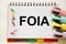 Focused on the business concept. Magnifier glass with the word FOIA Freedom of Information Act on a notepad. Business concept.