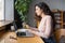 Focused businesswoman work on laptop hold expander in hand massaging muscles after computer overwork