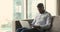 Focused busy millennial African business man using laptop