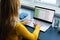 Focused caucasian woman sitting at desk, working from home and using laptop in sunny room