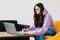 Focused caucasian young woman college student in eyeglasses studying with laptop distantly preparing for test exam writing essay