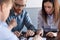 Focused colleagues assembling jigsaw puzzle during meeting