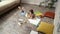 Focused cute little girl lying on the wooden floor in the living room at home and drawing with colorful pencils on a