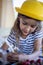 Focused cute little girl in summer yellow hat drawing writing imagination idea on breakfast table