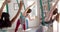 Focused diverse fitness teenage girls in aerial yoga class in big white room, slow motion