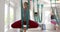 Focused diverse fitness women exercising in aerial yoga class in big white room, slow motion