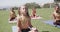 Focused diverse schoolgirls practicing yoga and meditating at stadium in slow motion