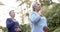 Focused diverse senior couple practicing yoga meditation in garden