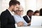 Focused diverse workers busy working at laptop at briefing