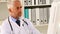 Focused doctor sitting at his desk using his computer