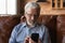 Focused elder 70s man using telemedicine app on smartphone