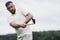 Focused at the end side of a stick. Portrait of golf player in the lawn and equipment in hand