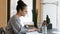 Focused ethnic woman work on laptop preparing report