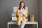 Focused European businesswoman standing near table at home or in office holds financial documents, serious young lady works