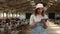 Focused farmer using tablet on ranch with goats