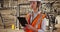 Focused female electrical worker at work on pad device at electrical facility