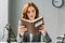 Focused female lawyer reading book with