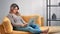 Focused freelancer female working remotely use laptop relaxing on yellow couch. 4k Dragon RED camera