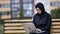 Focused freelancer modern Muslim woman working use laptop outdoor sitting on bench at city building