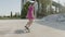 Focused girl with headphones riding longboard in skatepark