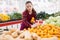 Focused girl salesperson in a store puts the tangerines on the counter