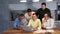 Focused group of male friends gathering around laptop, discussing and planning event with drinks on table at home