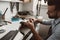 Focused on his work. Close-up photo of male jeweler making a new silver ring at his workbench.