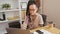 Focused hispanic business woman, an arm amputee, working diligently on laptop in elegant office