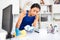 Focused Hispanic workwoman in overalls cleaning office